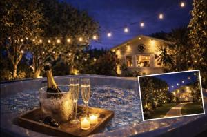 a bottle of wine and glasses on a table with a picture at Duck Lodge B&B in Pyecombe