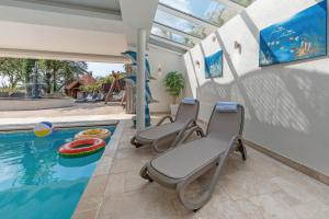 a pool with three chairs next to a swimming pool at Hamble House in Southampton