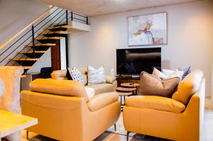a living room with two chairs and a television at Rustic Retreat in Swakopmund