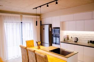 a kitchen with white cabinets and a wooden table with chairs at Rustic Retreat in Swakopmund