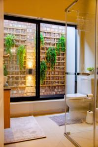 a bathroom with a toilet and a window with plants at Rustic Retreat in Swakopmund +21 photos