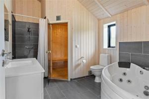 a bathroom with a tub and a toilet and a sink at 0340-Romo-Dvaergternen-2 in Høm +21 photos