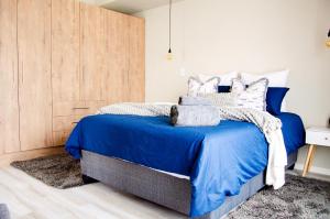 a bedroom with a blue bed with a wooden wall at Rustic Retreat in Swakopmund