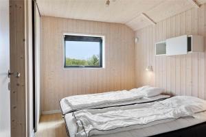 a bedroom with two beds and a window at 0340-Romo-Dvaergternen-2 in Høm