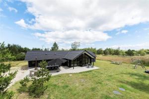 a house with a black roof in a field at 0340-Romo-Dvaergternen-2 in Høm