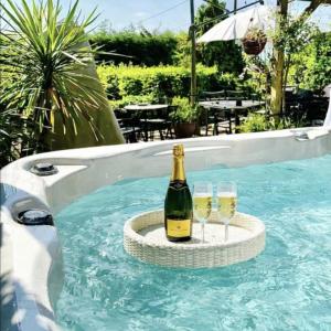 a bottle of champagne and two glasses in a swimming pool at Duck Lodge B&B in Pyecombe