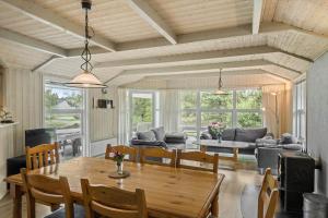 a dining room and living room with a table and chairs at 0223-Romo-Sonderstrandvej-12 in Høm