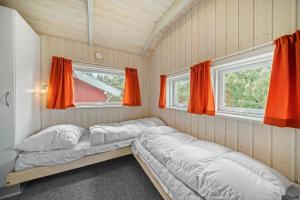 two beds in a room with two windows at 0223-Romo-Sonderstrandvej-12 in Høm