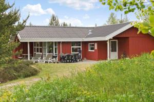 a red house with tables and chairs in front of it at 0223-Romo-Sonderstrandvej-12 in Høm