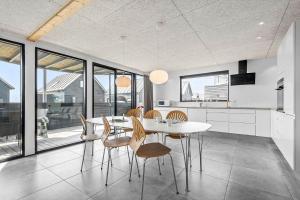 a kitchen with a white table and chairs and windows at 0433-Romo-Vestergade-345 in Høm