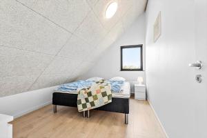 a bedroom with a bed in a white room at 0433-Romo-Vestergade-345 in Høm