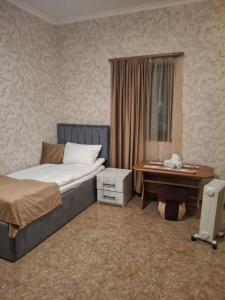 a bedroom with a bed and a table and a desk at Tatev 1 in Tatʼev