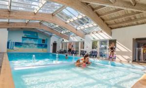 a swimming pool with people in the water at ZEcamping animations espace aquatique piscine couverte et restaurant in Saint-Hilaire-de-Riez