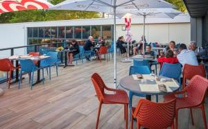 a group of people sitting at tables on a deck at ZEcamping animations espace aquatique piscine couverte et restaurant in Saint-Hilaire-de-Riez