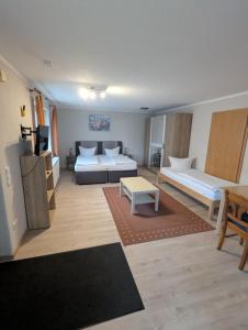 a large living room with two beds and a table at Pension Grübel in Lindau