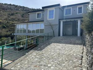 a house with a stone walkway in front of it at Qyteza guest house in Shkodër