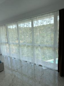 a large window with white curtains in a room at Qyteza guest house in Shkodër