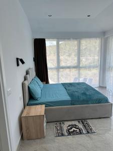 a bedroom with a bed and a large window at Qyteza guest house in Shkodër