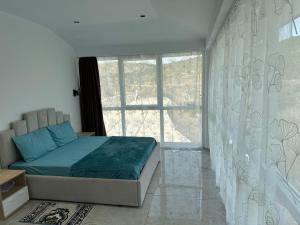 a bedroom with a bed and a large window at Qyteza guest house in Shkodër