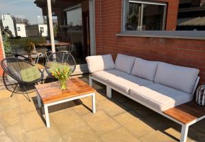a couch and a table on a patio at Refugio Wolvenberg in Oudenaarde