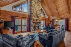 a living room with leather furniture and a stone fireplace at Lazy Bear Retreat - Wifi, Pet Friendly, Grill, Fire Pit, Fireplace, Deck, Golf, Hiking in Morton Grove