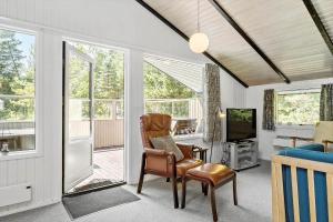 a living room with a chair and a television at 0312-Romo-Vagtelvej-8 in Høm