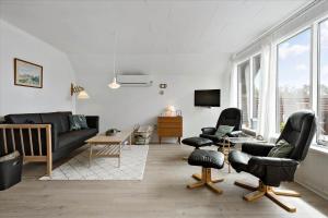 a living room with black leather chairs and a couch at 0309-Romo-Stagebjergvej-13 in Høm