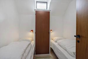 a bedroom with two beds and a door with a window at 0309-Romo-Stagebjergvej-13 in Høm