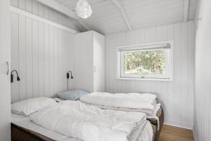 two beds in a white room with a window at 0252-Romo-Kromosevej-6 in Høm