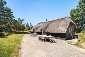 a building with a grass roof with a picnic table at 0209-Romo-Vrabyvej-34 in Høm