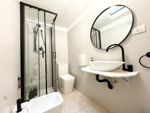 a white bathroom with a sink and a mirror at Kalma - at the picturesque Via Stretta in Cagliari +6 photos