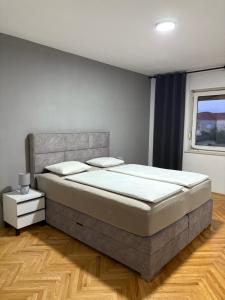 a bedroom with a large bed and a window at Apartman Seven Kaštel Stari in Kaštela
