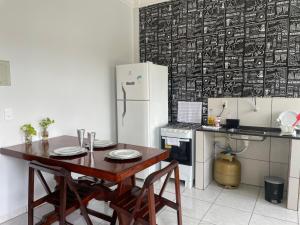 a kitchen with a wooden table and a refrigerator at Flat Centro 302 in Tangara da Serra