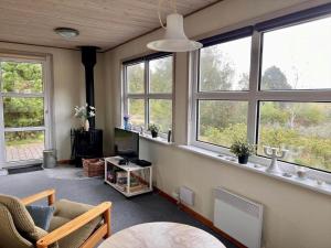 a living room with windows and a couch and a tv at 0210-Romo-Vestergardsvej-10 in Høm