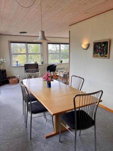 a dining room with a wooden table and chairs at 0210-Romo-Vestergardsvej-10 in Høm