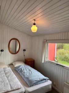 a bedroom with a bed and a mirror and a window at 0210-Romo-Vestergardsvej-10 in Høm