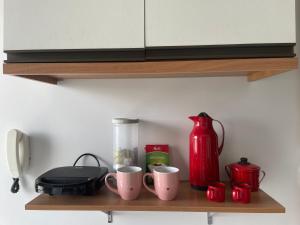 a shelf with cups and a blender on it at Flat Centro 302 in Tangara da Serra