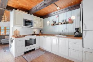 a kitchen with white cabinets and a wooden ceiling at 0310-Romo-Langdalsvej-61 in Høm +23 photos