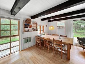a dining room with a wooden table and chairs at 0310-Romo-Langdalsvej-61 in Høm