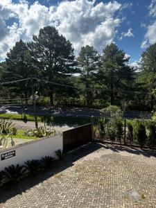 a garden with a fence and a brick driveway at Motel Tentação (Adult Only) in Canela +17 photos