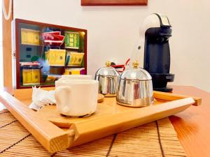 a table with a coffee maker and tea pots on it at Splendido appartamento tra mare e storia in Sorso