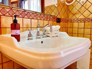 a bathroom sink with a red soap bottle on it at Splendido appartamento tra mare e storia in Sorso +22 photos