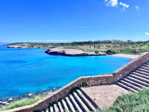 a set of stairs next to a body of water at Splendido appartamento tra mare e storia in Sorso