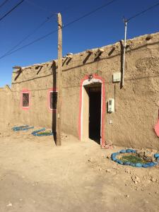 a building with a door in the side of it at Merzouga Hostel in Merzouga