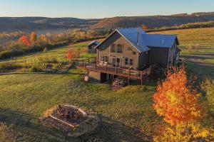 an aerial view of a house in a field at Fawn Crest -Timber Frame Retreat, Firepit, 20 acre in Alfred Station