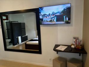 a mirror on the wall of a room with a bedroom at Motel Tentação (Adult Only) in Canela