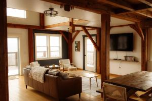 a living room with a couch and a table at Fawn Crest -Timber Frame Retreat, Firepit, 20 acre in Alfred Station