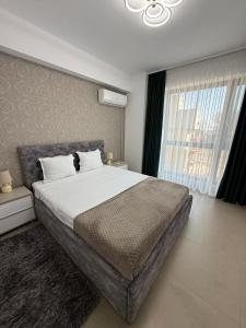 a bedroom with a large bed and a large window at RoApart Riva Lake Studiouri si Apartamente 2-3 camere cu vedere lac -parcare privata in Mamaia +139 photos