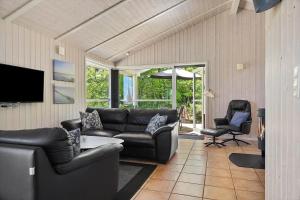 a living room with a leather couch and chairs at 0390-Romo-Lyngvejen-45-A in Høm
