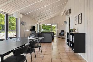 a living room with a dining table and chairs at 0390-Romo-Lyngvejen-45-A in Høm